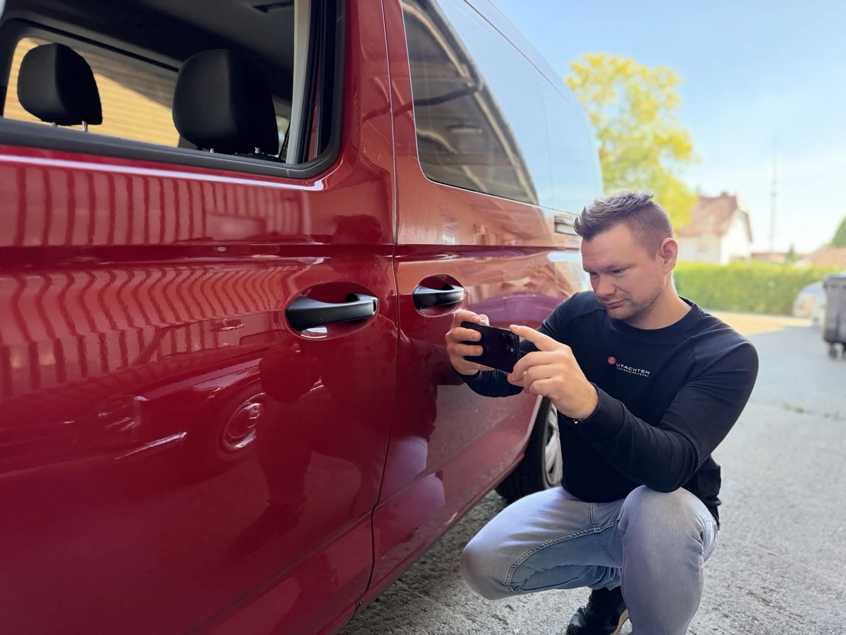 Patrick Weiß fotografiert einen Schaden an einem roten Fahrzeug