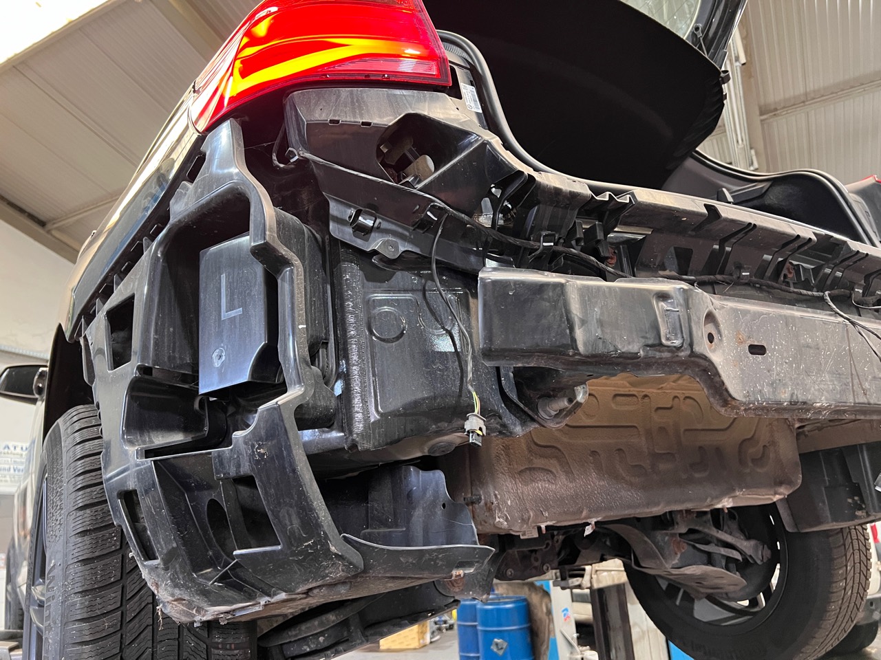 Detailaufnahme des linken Heckbereichs am BMW bei abgenommenem Stoßfänger