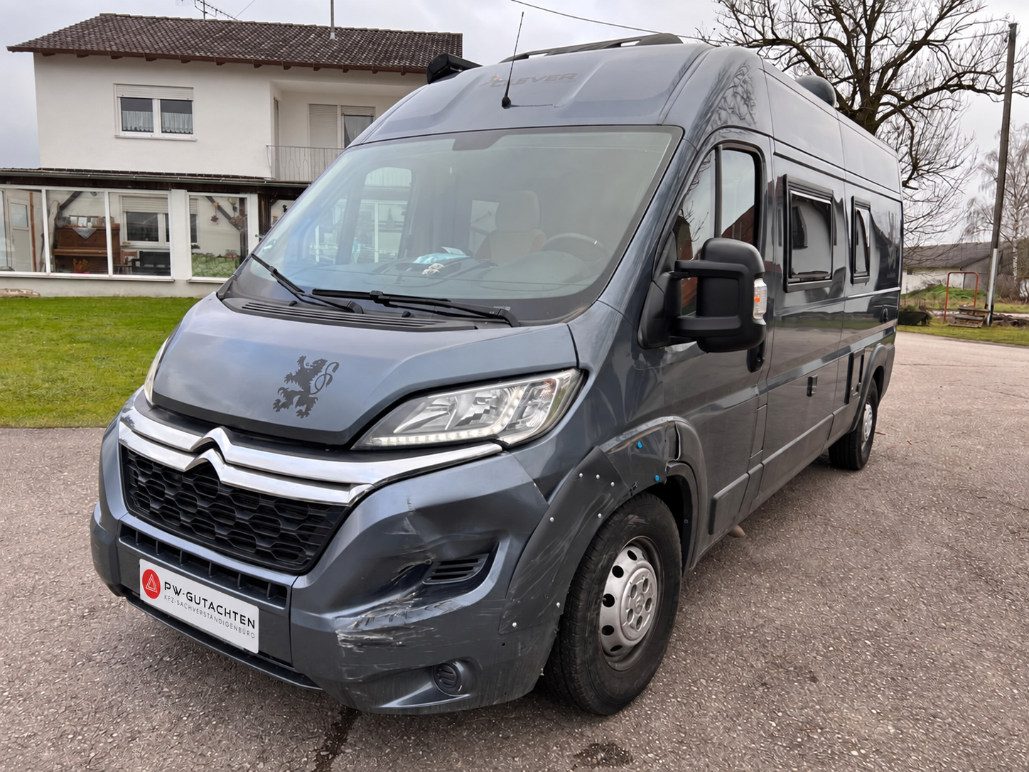 Wohnmobil mit beschädigter Front und PW-Gutachten-Logo anstelle des Kennzeichens